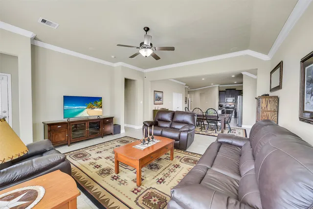 a living room with furniture a flat screen tv and a window