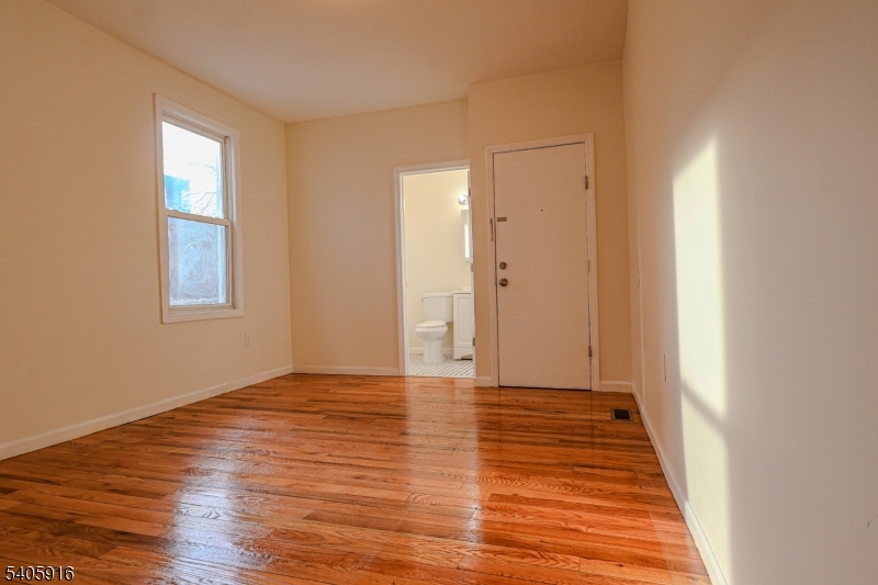 101 Hedden Terrace Newark, NJ 07108 - Photo 12 of 34 a view of an empty room with wooden floor and a window