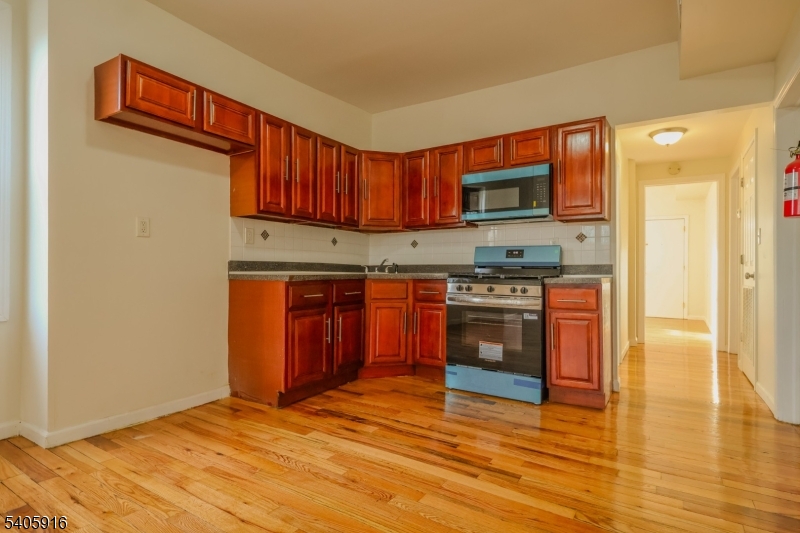 101 Hedden Terrace Newark, NJ 07108 - Photo 19 of 34 a kitchen with stainless steel appliances granite countertop a stove a sink and a microwave