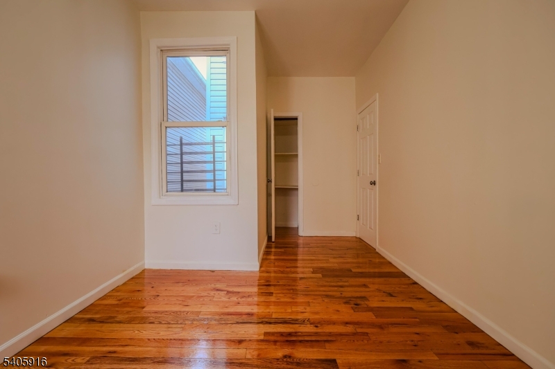 101 Hedden Terrace Newark, NJ 07108 - Photo 24 of 34 a view of an empty room with wooden floor and a window