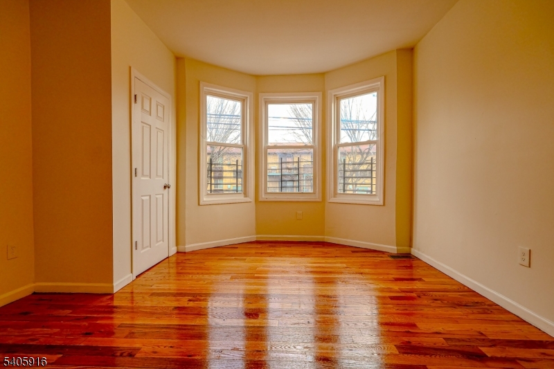 101 Hedden Terrace Newark, NJ 07108 - Photo 3 of 34 a view of an empty room with wooden floor and a window