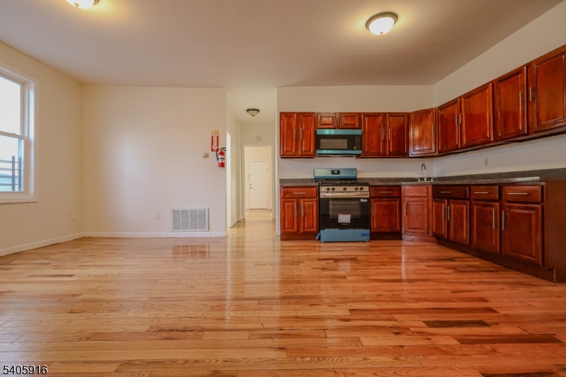 101 Hedden Terrace Newark, NJ 07108 - Photo 6 of 34 a large kitchen with stainless steel appliances granite countertop a stove cabinets and wooden floor