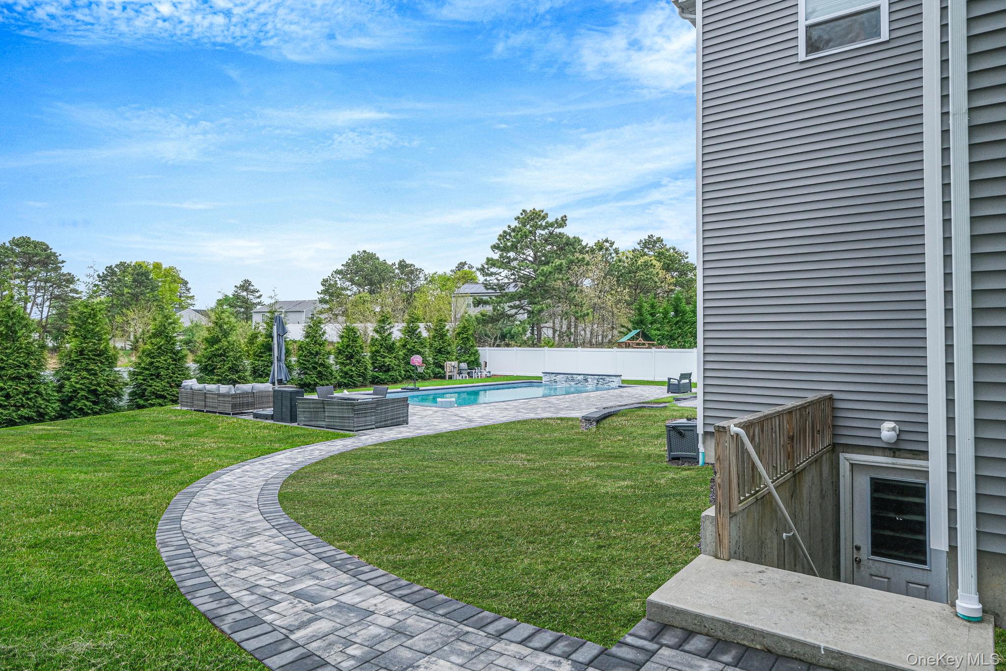 86 Country Road Medford, NY 11763 - Photo 12 of 47 .52 acres with 44’ x 20’ gas-heated Jandy TruGuard mineral in-ground pool with a 10’ sundeck, lounge area, and gorgeous waterfall feature