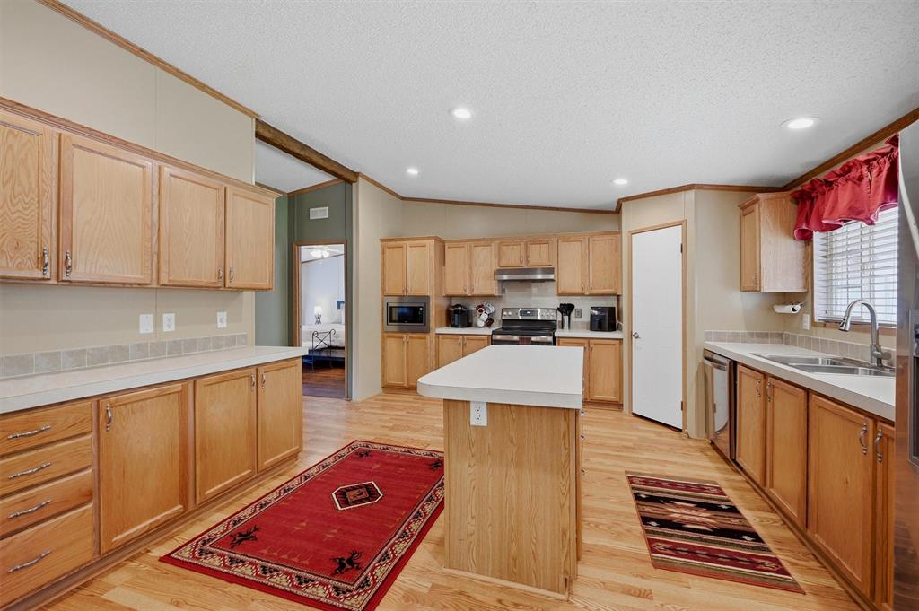 212 Sunset Road Pottsboro, TX 75076 - Photo 11 of 40 a large kitchen with stainless steel appliances kitchen island granite countertop a refrigerator and stove top oven