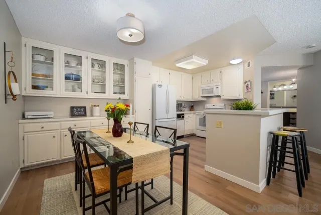 a kitchen with a table chairs and white cabinets