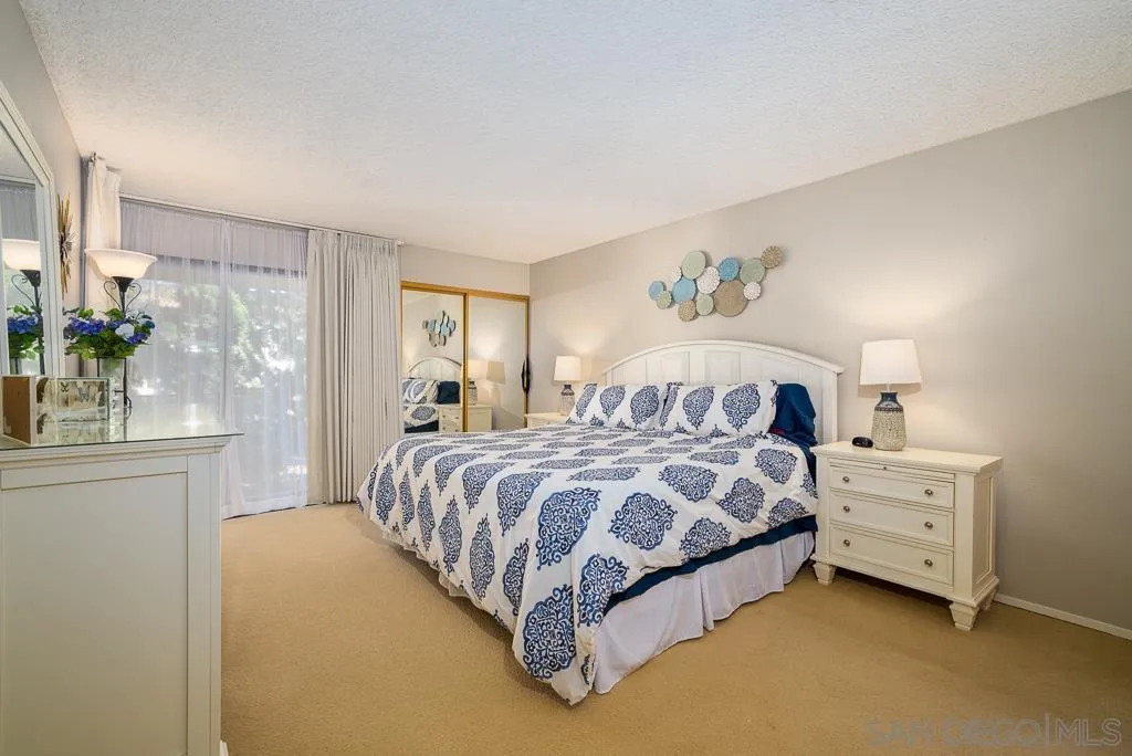 17617 Pomerado Road, Unit 215 San Diego, CA 92128 - Photo 20 of 64 a spacious bedroom with a bed and a chandelier
