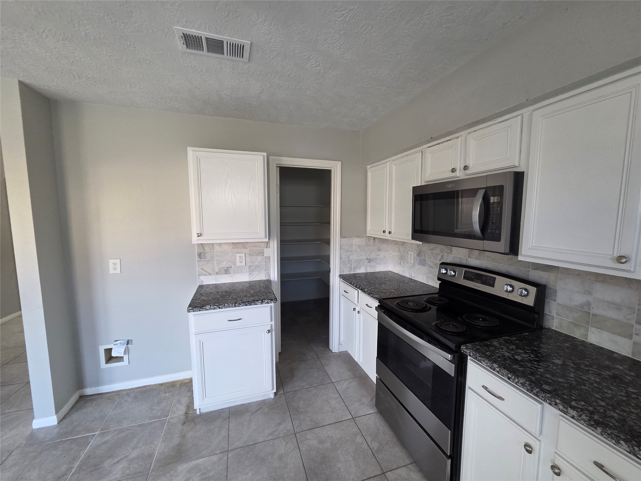 32018 Annice Lane Pinehurst, TX 77362 - Photo 8 of 19 Discover culinary convenience in this modern kitchen featuring sleek granite countertops, stainless steel appliances, and a spacious walk-in pantry perfect for all your storage needs.