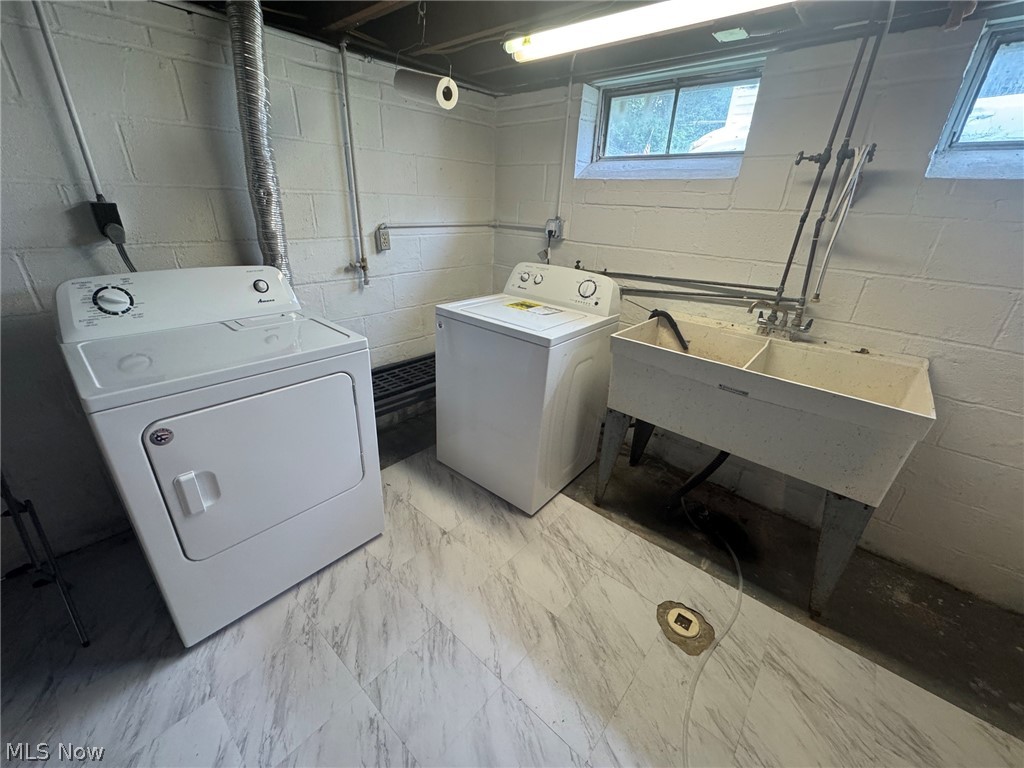 1132 Gordon Road Cleveland, OH 44124 - Photo 24 of 28 Dedicated laundry area featuring a washer and dryer, utility sink with dual basins, and light-toned flooring