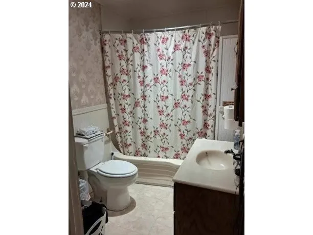 a bathroom with a toilet and a shower curtain
