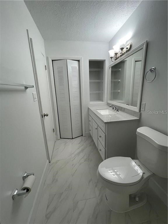 232 Afton Square, Unit 112 Altamonte Springs, FL 32714 - Photo 11 of 13 a bathroom with a sink a toilet a mirror and vanity