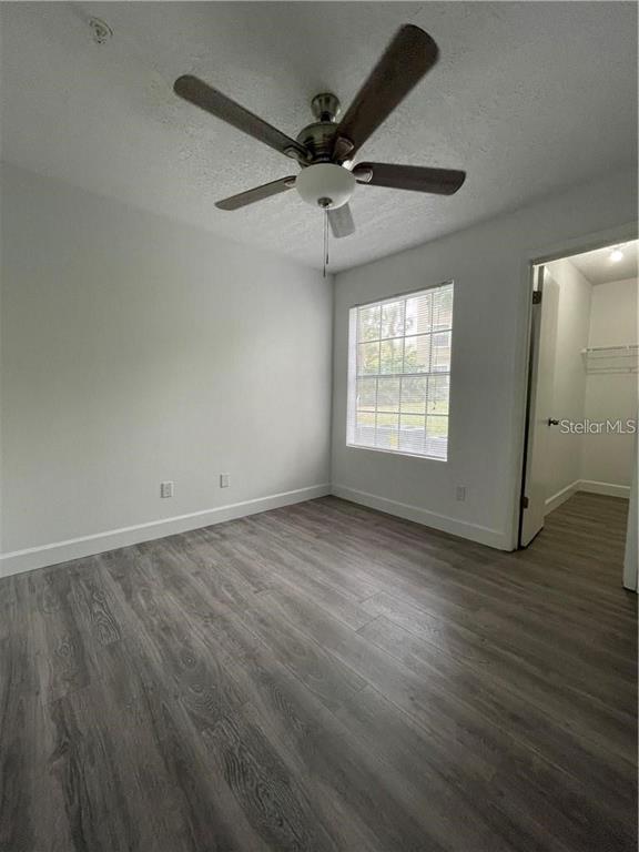 232 Afton Square, Unit 112 Altamonte Springs, FL 32714 - Photo 12 of 13 an empty room with wooden floor fan and windows