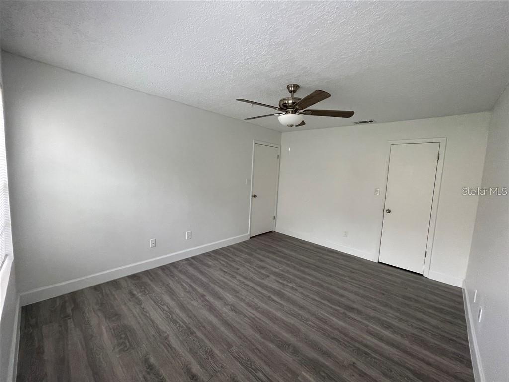 232 Afton Square, Unit 112 Altamonte Springs, FL 32714 - Photo 13 of 13 a view of a room with wooden floor and a ceiling fan