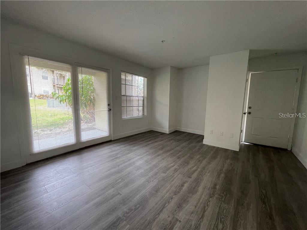 232 Afton Square, Unit 112 Altamonte Springs, FL 32714 - Photo 2 of 13 an empty room with wooden floor and windows