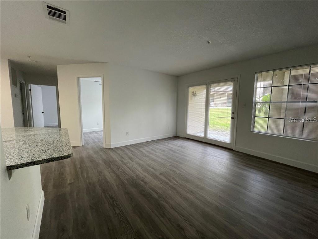232 Afton Square, Unit 112 Altamonte Springs, FL 32714 - Photo 4 of 13 an empty room with wooden floor and windows