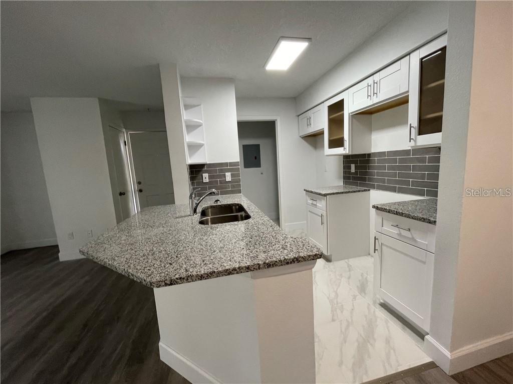 232 Afton Square, Unit 112 Altamonte Springs, FL 32714 - Photo 5 of 13 a kitchen with stainless steel appliances granite countertop a sink stove and refrigerator