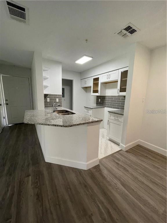 232 Afton Square, Unit 112 Altamonte Springs, FL 32714 - Photo 6 of 13 a kitchen with kitchen island granite countertop a sink cabinets and stainless steel appliances