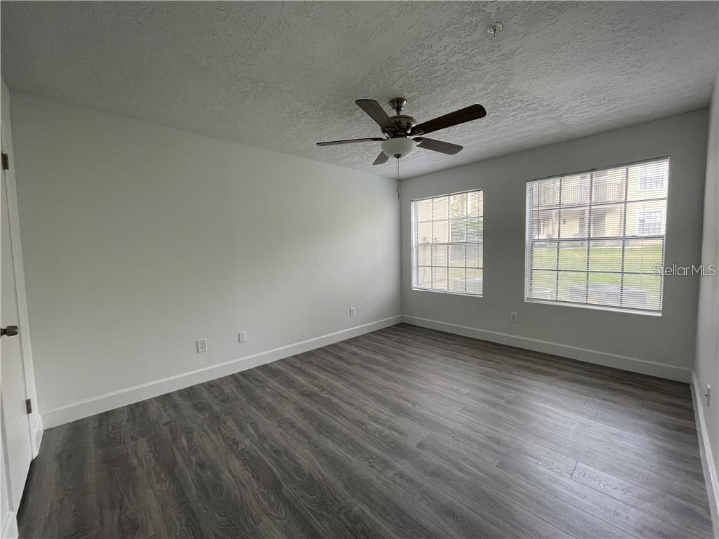 232 Afton Square, Unit 112 Altamonte Springs, FL 32714 - Photo 8 of 13 an empty room with wooden floor fan and windows