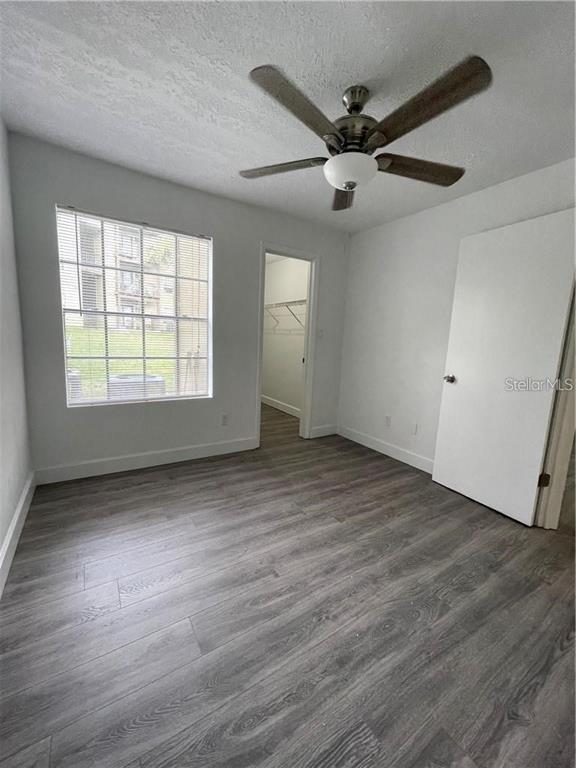 232 Afton Square, Unit 112 Altamonte Springs, FL 32714 - Photo 9 of 13 an empty room with wooden floor fan and windows