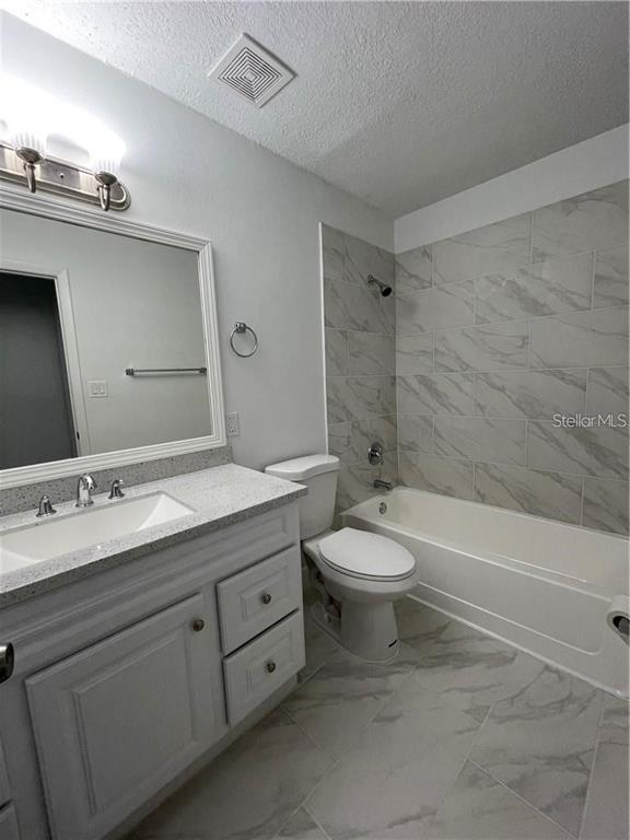 232 Afton Square, Unit 112 Altamonte Springs, FL 32714 - Photo 10 of 13 a bathroom with a granite countertop toilet a sink and a bathtub