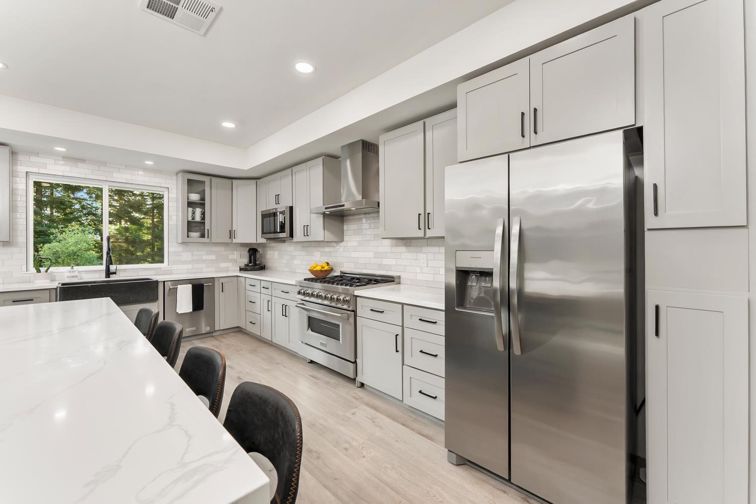 6762 Highland Road Granite Bay, CA 95746 - Photo 24 of 90 a kitchen with stainless steel appliances granite countertop a refrigerator a stove a sink dishwasher a refrigerator with white cabinets and wooden floor