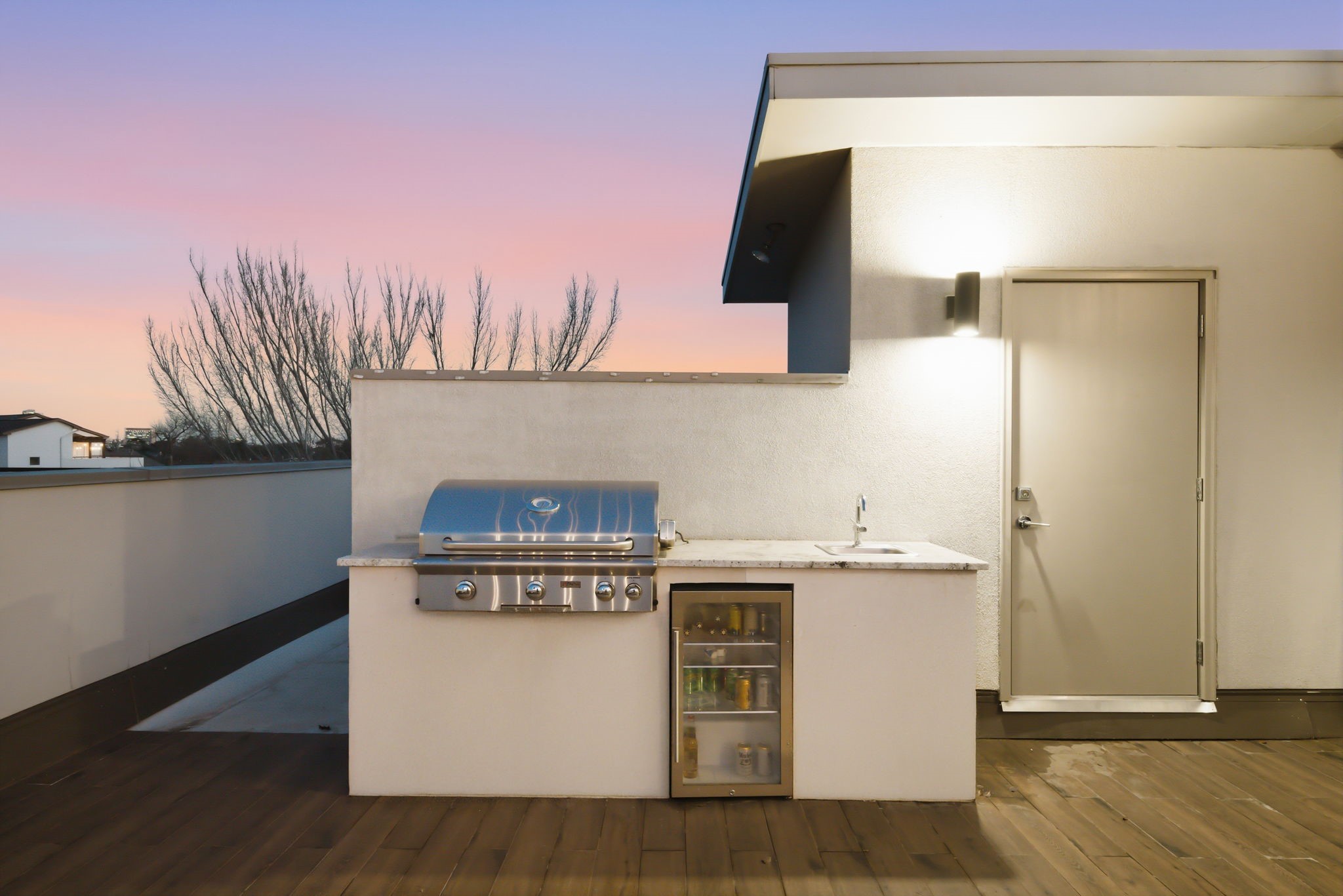 1405 Vermont Street, Unit A Houston, TX 77006 - Photo 39 of 46 Gourmet summer kitchen anchors this expansive rooftop deck, featuring a high-end gas grill, stainless sink, and beverage cooler. White quartz countertops provide ample prep space for outdoor hosting, while the low-maintenance layout offers a seamless transition to the al fresco dining and lounge areas. This private Bradford Mews retreat is a sophisticated setting for sunset gatherings.