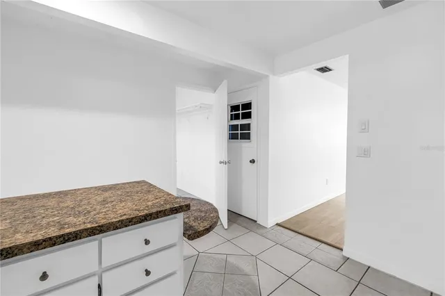 a kitchen with granite countertop a refrigerator and cabinets