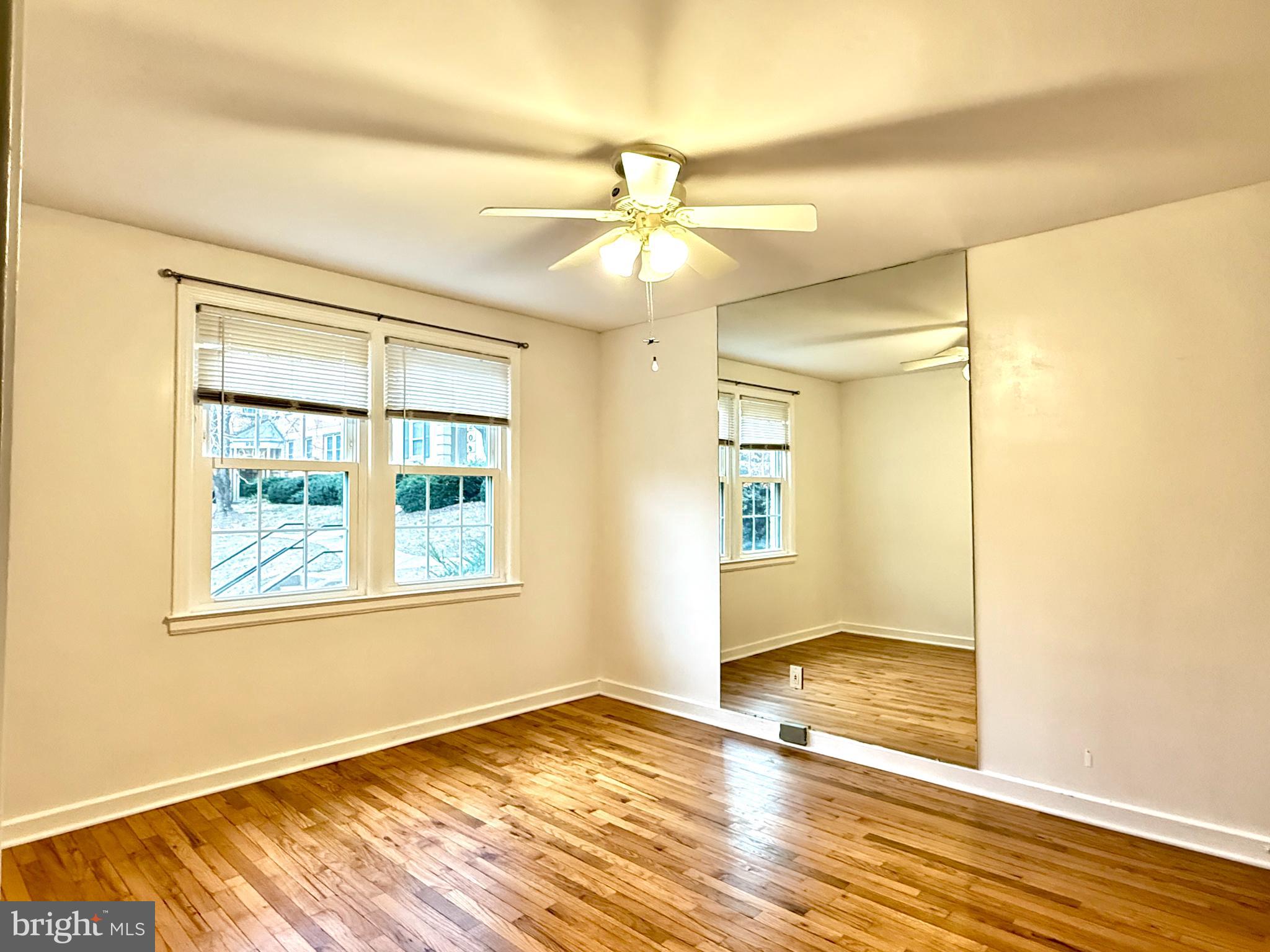 2205 Washington Avenue, Unit 102 Silver Spring, MD 20910 - Photo 11 of 20 a view of an empty room with wooden floor and a window