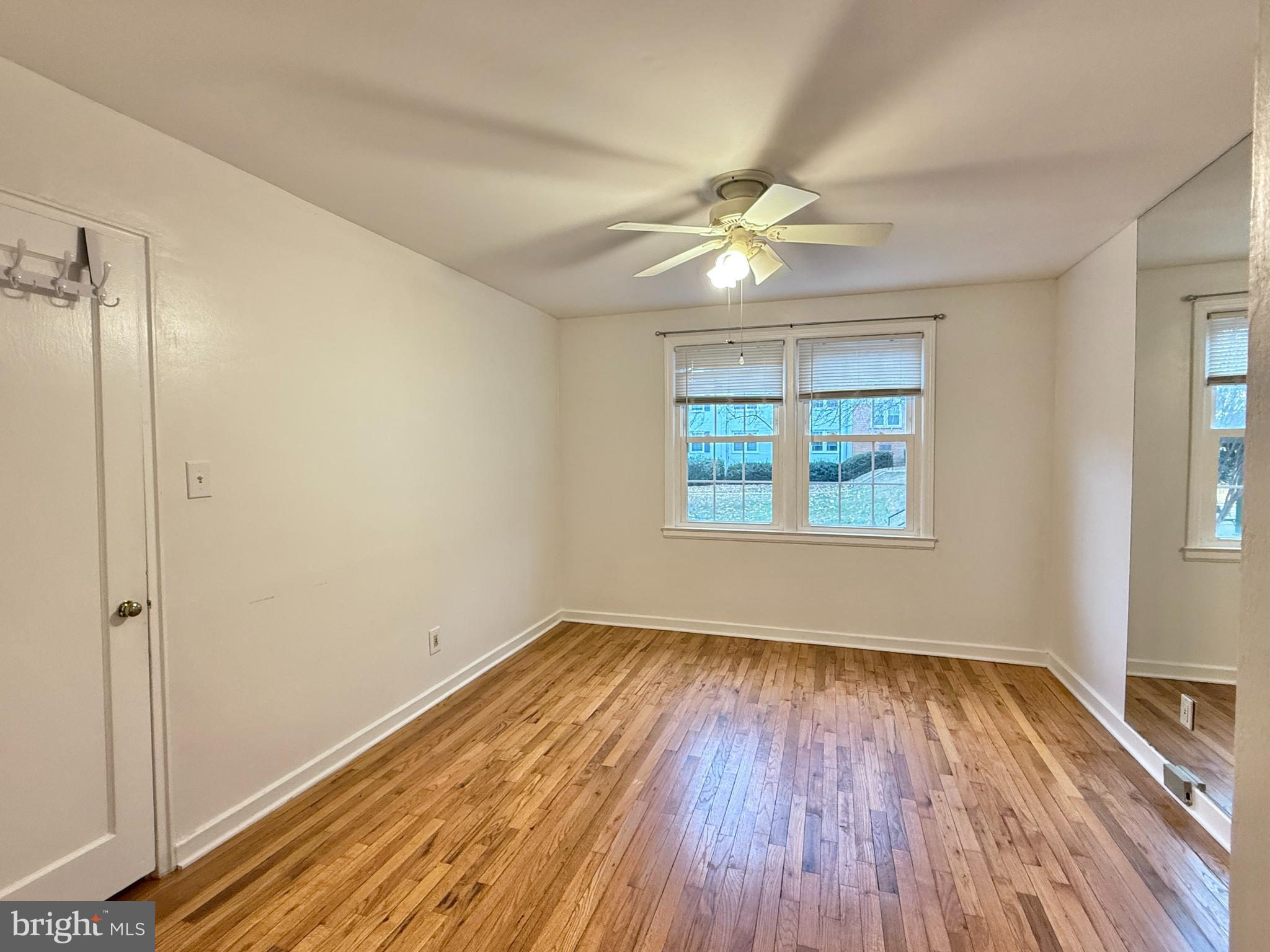 2205 Washington Avenue, Unit 102 Silver Spring, MD 20910 - Photo 12 of 20 an empty room with wooden floor fan and windows