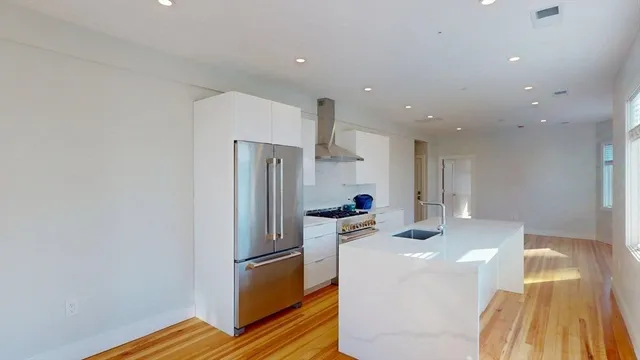 a view of kitchen and hall with wooden floor
