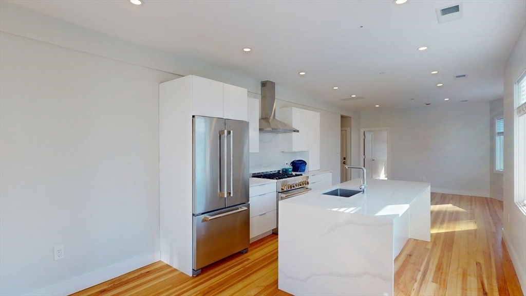 179 Appleton Street, Unit 2 Cambridge, MA 02138 - Photo 4 of 23 a kitchen with stainless steel appliances a refrigerator and a stove top oven