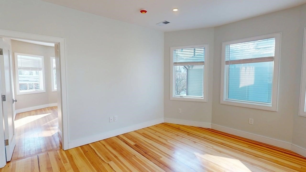 179 Appleton Street, Unit 2 Cambridge, MA 02138 - Photo 8 of 23 a view of empty room with wooden floor and fan
