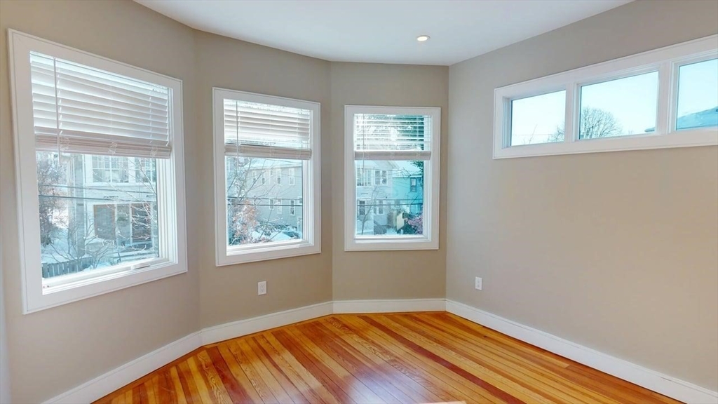 179 Appleton Street, Unit 2 Cambridge, MA 02138 - Photo 9 of 23 a view of an empty room with wooden floor and a window