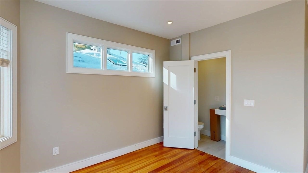 179 Appleton Street, Unit 2 Cambridge, MA 02138 - Photo 10 of 23 a view of a room with wooden floor and a window