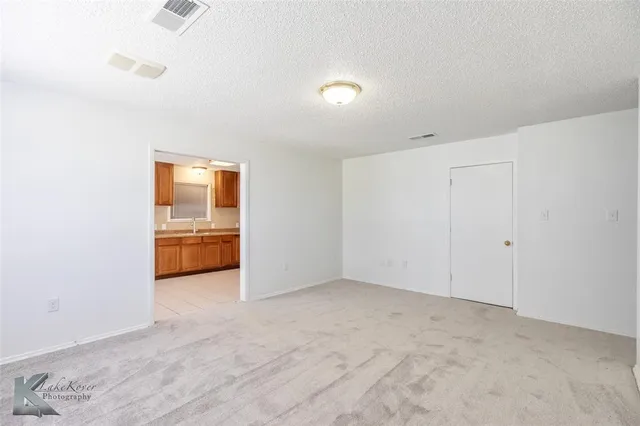 a view of a kitchen with a sink and dishwasher a refrigerator with white cabinets