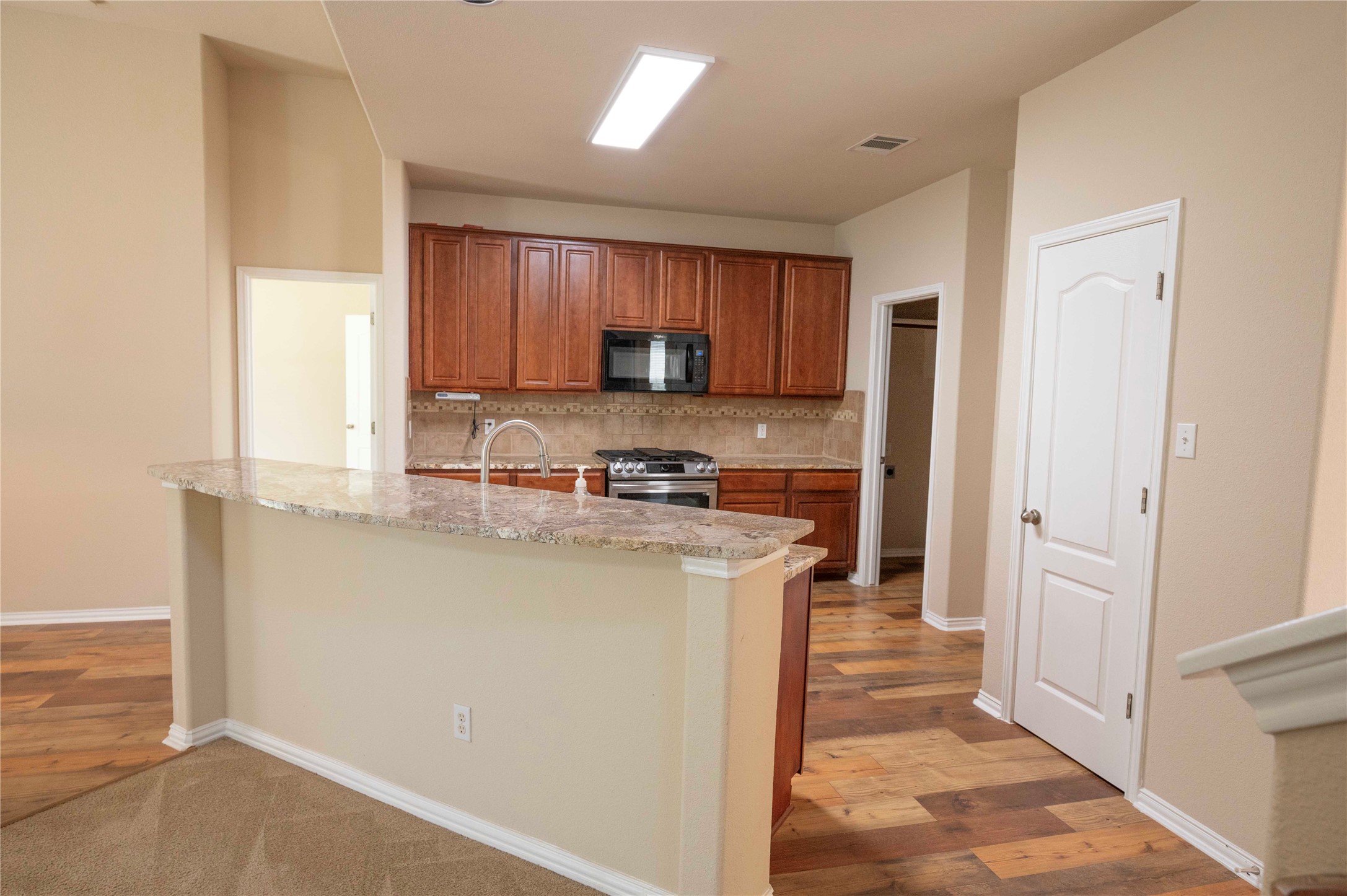 2070 Intrepid Drive Buda, TX 78610 - Photo 3 of 31 Granite counters and rich wood cabinetry create a functional, stylish kitchen space.