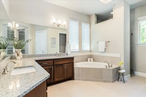 a spacious bathroom with a granite countertop tub sink and mirror