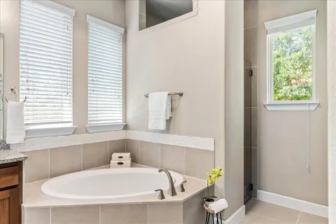 a bathroom with bathtub and window