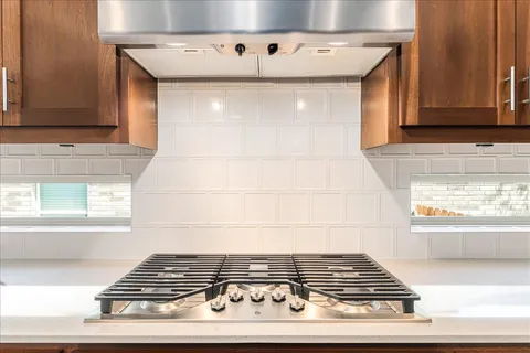 a stove top oven sitting inside of a kitchen