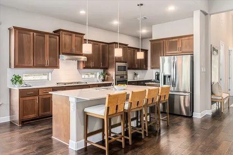 a kitchen with kitchen island granite countertop wooden floors and stainless steel appliances