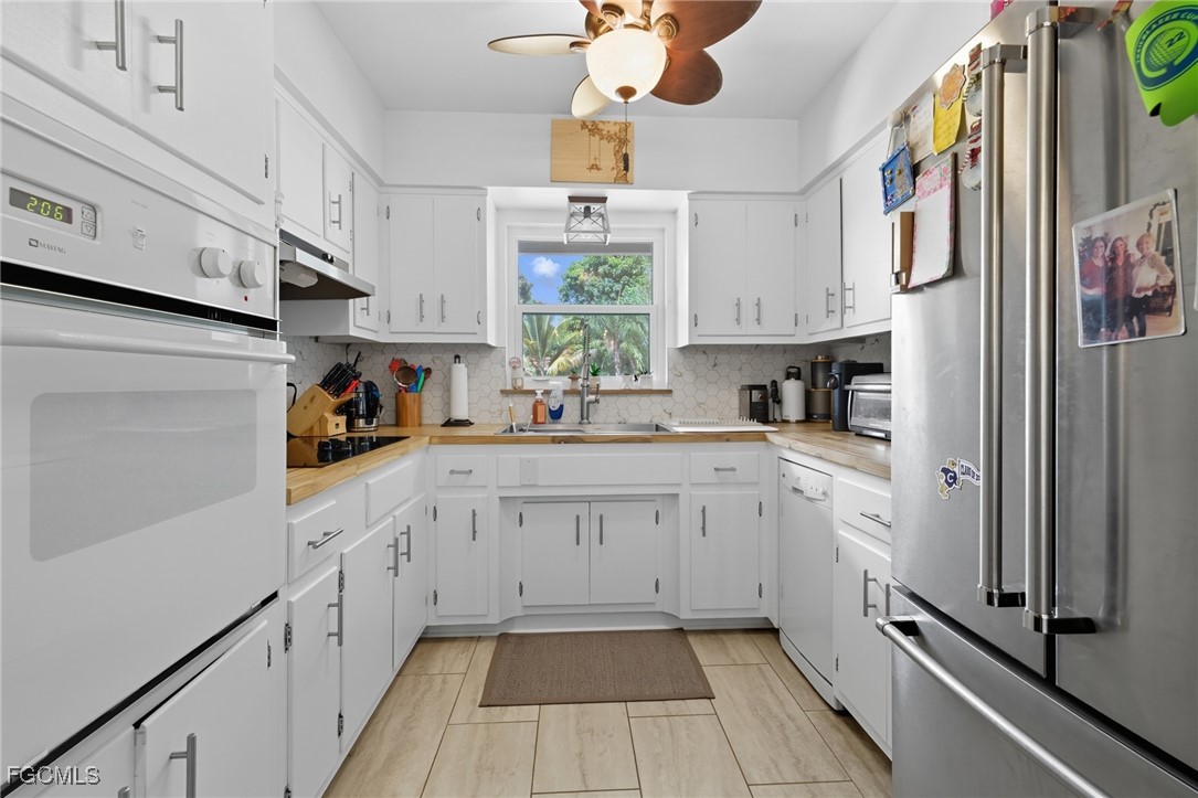 1420 Mandel Road Fort Myers, FL 33919 - Photo 17 of 41 a kitchen with stainless steel appliances white cabinets and a window