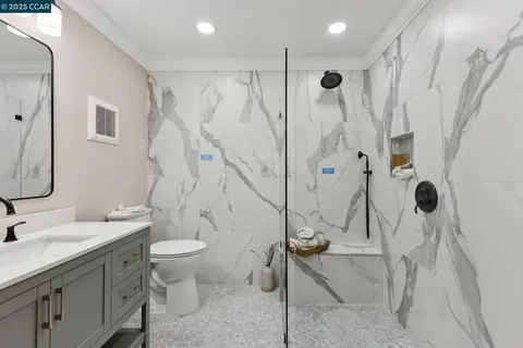 a bathroom with a sink a toilet and shower