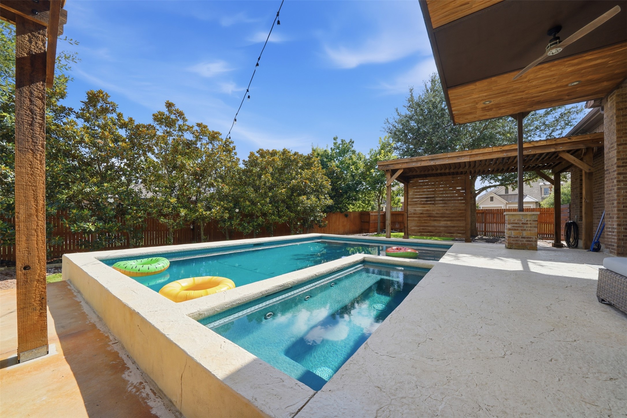 8729 Vantage Point Drive Austin, TX 78737 - Photo 26 of 33 An inviting backyard oasis offers a sparkling pool and spa, complemented by a shaded pergola and overhead lighting for evening enjoyment.