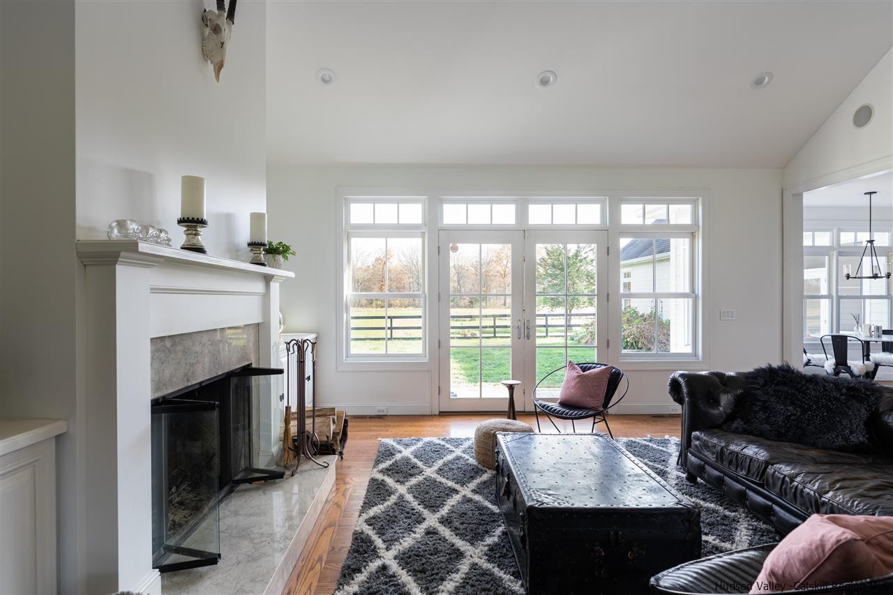 383 Pine Bush Road Stone Ridge, NY 12484 - Photo 6 of 35 a living room with furniture a fireplace and large windows