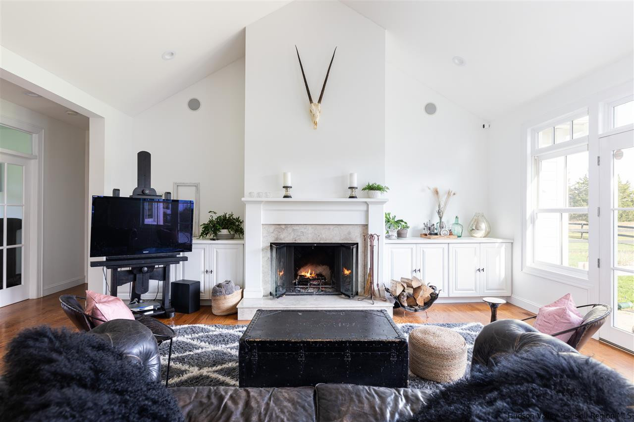 383 Pine Bush Road Stone Ridge, NY 12484 - Photo 7 of 35 a living room with furniture a fireplace and a flat screen tv