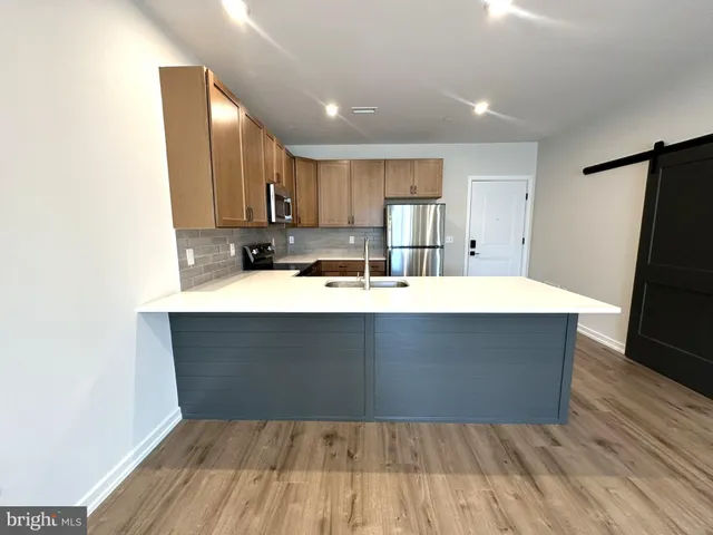 a kitchen with kitchen island sink refrigerator and cabinets