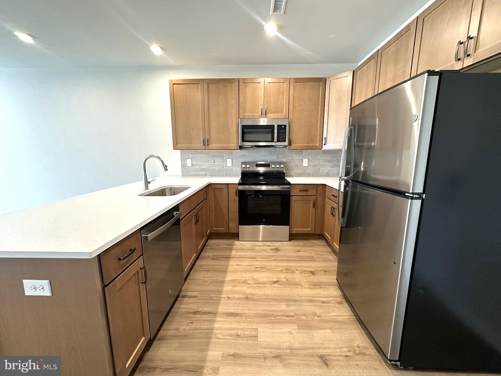 409 West Butler Avenue, Unit 318 Chalfont, PA 18914 - Photo 7 of 32 a kitchen with stainless steel appliances granite countertop a refrigerator a sink a stove top oven and a refrigerator