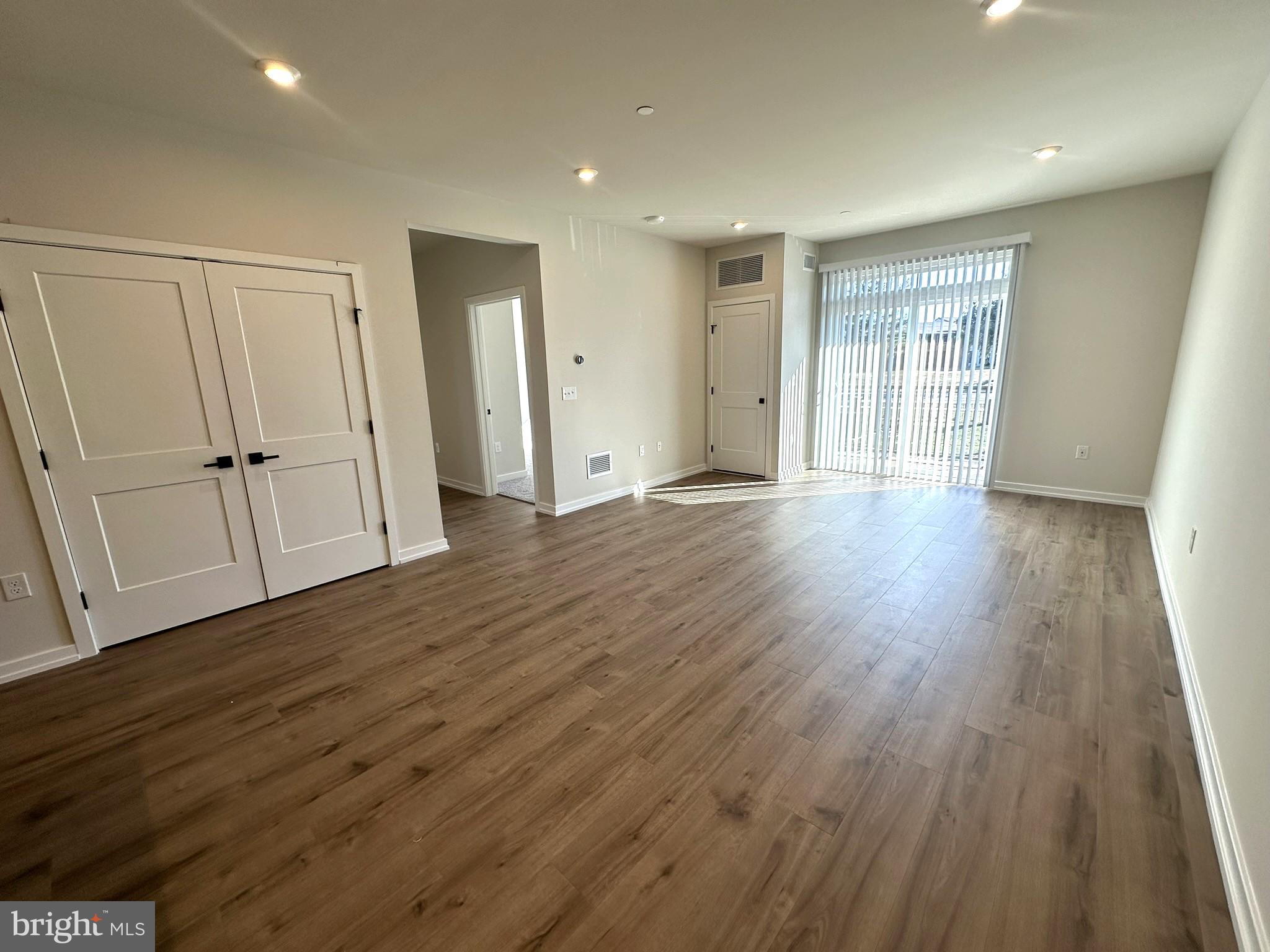 409 West Butler Avenue, Unit 318 Chalfont, PA 18914 - Photo 9 of 32 a view of an empty room with wooden floor and entryway