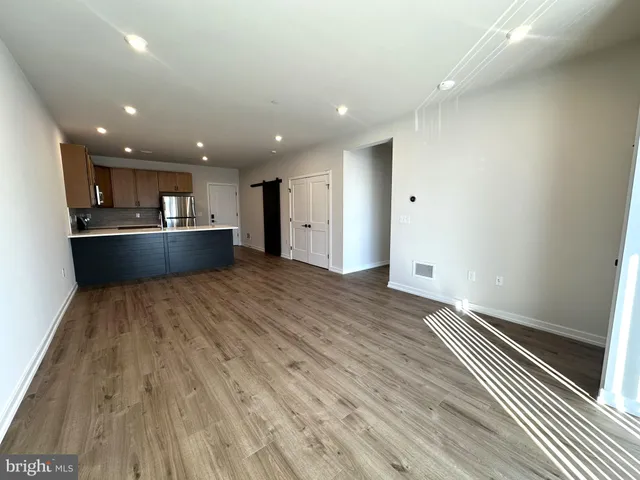 a view of kitchen with wooden floor and stainless steel appliances