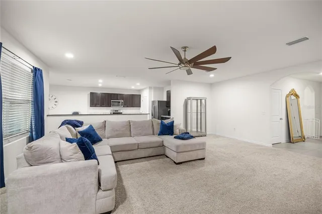 a living room with furniture and a ceiling fan