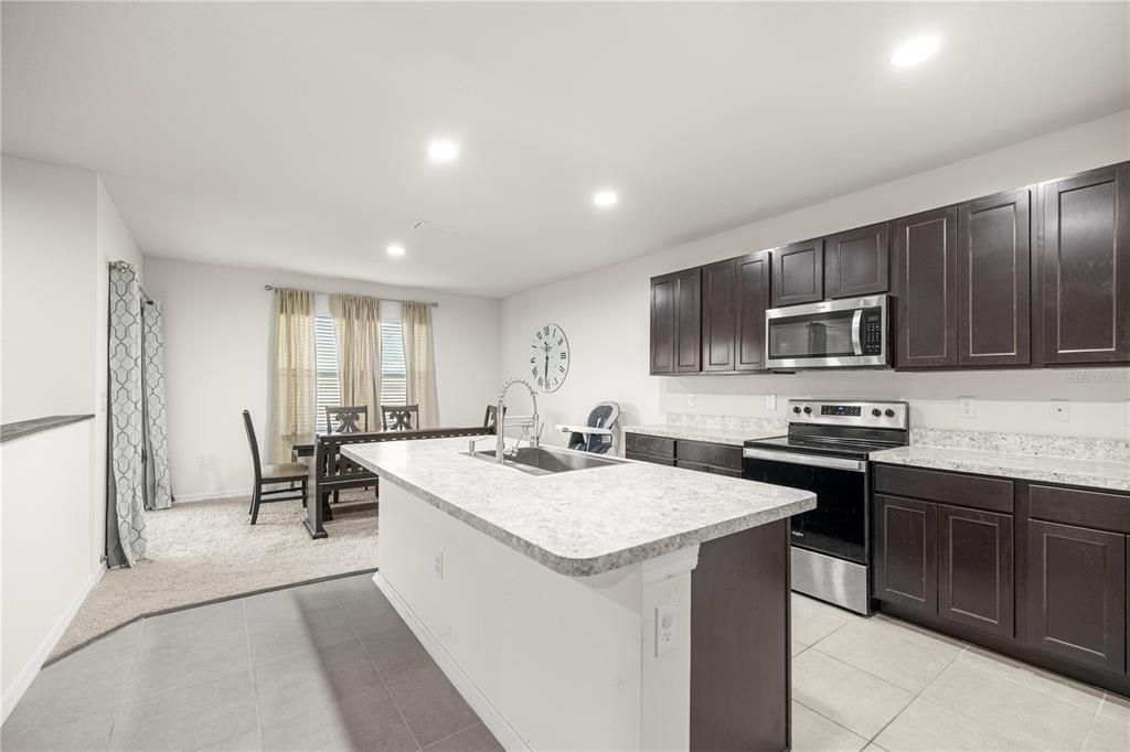 3833 Southeast 98th Place Belleview, FL 34420 - Photo 16 of 34 a kitchen with a sink stove and microwave